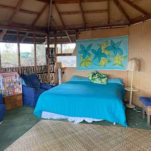 King size bed, couch and easy chairs. Small table. Lots of screens for breezes but very private.