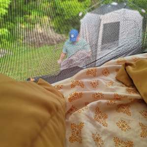 First morning looking out of rooftop tent as my husband was setting up the privy tent. Though out of focus, you can see how beautiful the site is. Stacked wood on the edge of the tree line!