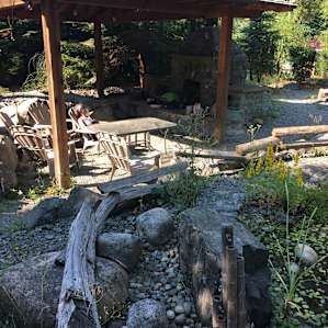 A lovely garden surrounded by large trees.