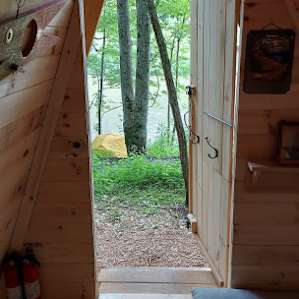 View out the door towards the river and the campsite across the street. Hooks are the door were great for our jackets. Door latches from the inside and outside.