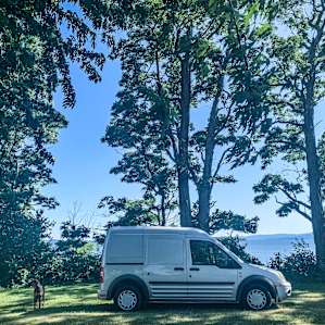 Our tiny camper (and our dog Forest) at the spot in the yard overlooking Lake Champlain and the Adirondacks beyond.