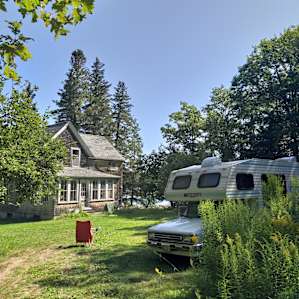 Campsite on lawn in front of unused house