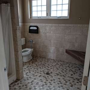 Both shower rooms have showers with hot water, flush toilets, a bench, and numerous hooks for hanging towels and wet clothes.