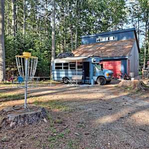 @bigsirbus setup with awning and RV mat. Power comes from the garage behind the bus. Farm animals about 30 ft from driver side door. Slight downhill away from garage, but didn't need levelers. Not pictured: slackline, basketball hoop, 3 doggos :)