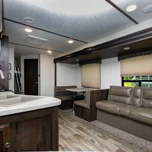Inside the trailer is a small living area with sofa and dining space.
