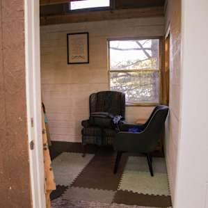 The bunkie entrance, the main level has two chairs, a desk, some small hooks for coats and keys and a padded floor.