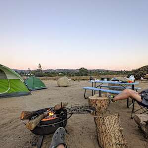 camp set up with tents and fire going.