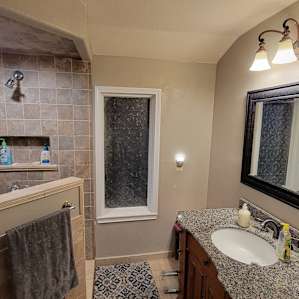 Full bath with walk-in shower, with the toilet behind the door, and tankless water heater for nearly unlimited hot water.