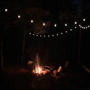 Campfire and string lights at night.