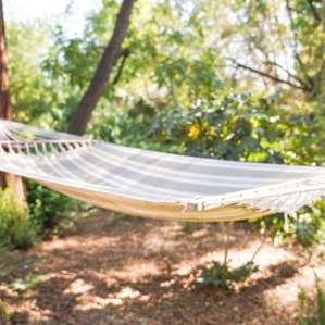A large hammock hung secured between two trees.