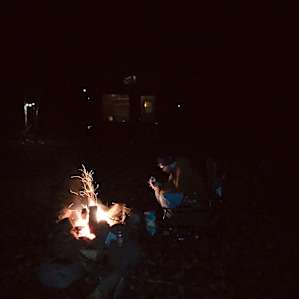 Fire pit with twinkle lit cabin in the background.