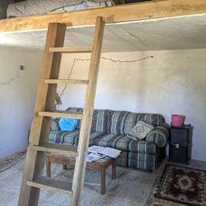 I'm standing at the front door. Below is a sleeper sofa and the loft has a cozy queen bed..