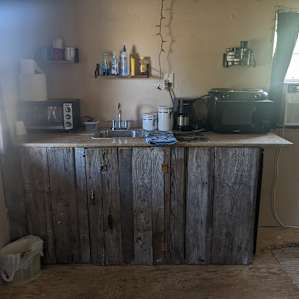 Standing at the door again, rustic mini kitchen area. Mini fridge to the right. Microwave, electric burners, coffee pot, toaster oven, various spices and soaps. Don't forget to look under the cabinets where you'll find utensils, pans, plates, etc.