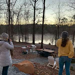 Sipping warm beverages at dawn, looking from the camper toward the water.