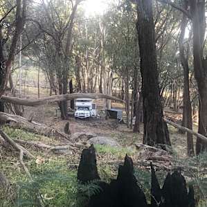 Campsite next to drinking tap water, fire pit and covered wood pile