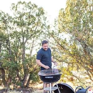 Preparing the grill to cook dinner in the common area. Our campsite also had a fire pit that could be used as a grill.