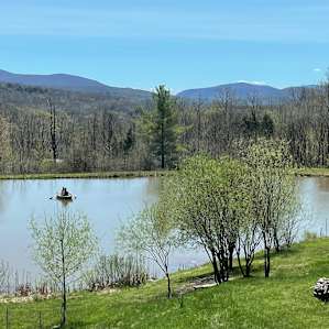 View of the pond on the property, mountains on the horizon.