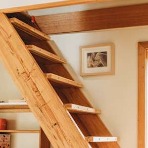 Stairs leading from the kitchen to a beautifully designed room with a double bed.