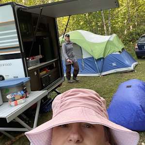 BIG tent tiny camper and lots of room for two cars and a picnic table and fire pit