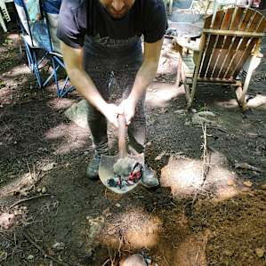 Dig a hole and fill it with hot rocks from the campfire, then place your well wrapped roast. In this case we wrapped the pernil with banana leaves and foil.