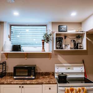 The kitchen comes with a stove top, microwave, coffee maker, and other essential kitchen appliance