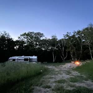 The site at night. To the right is the fire pit, just out of view on right is compost toilet. 32’ camper.