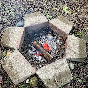 Nice fire pit with bricks around it and there’s a grate for cooking if you choose.