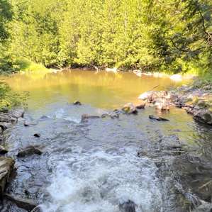 The swimming hole was cold, deep, and refreshing.