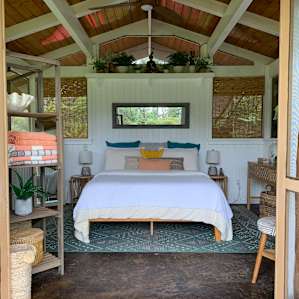 Indoor the beautifully decorated hale. Screened windows and a ceiling fan cool you by day and a super cozy bed keeps you warm at night. Plenty of shelving, hooks and outlets available.
