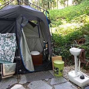 Composting toilet with shower attached and hand washing sink. Includes towels and shower sandals in a variety of sizes.