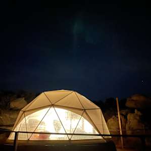 The dome home at night lit up.