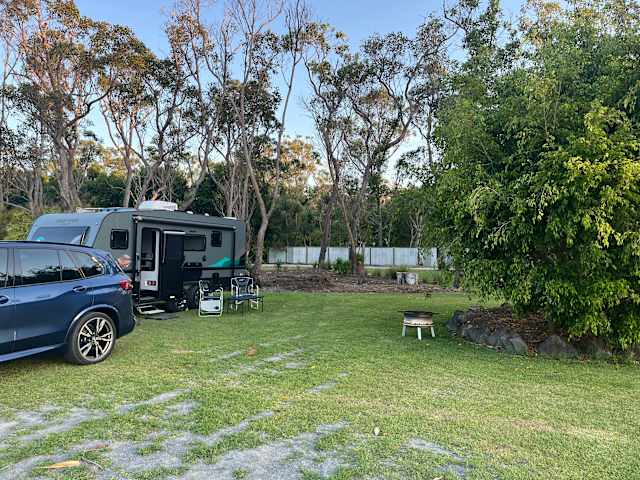 RV campsite beside a lily-covered pond ringed by eucalyptus trees