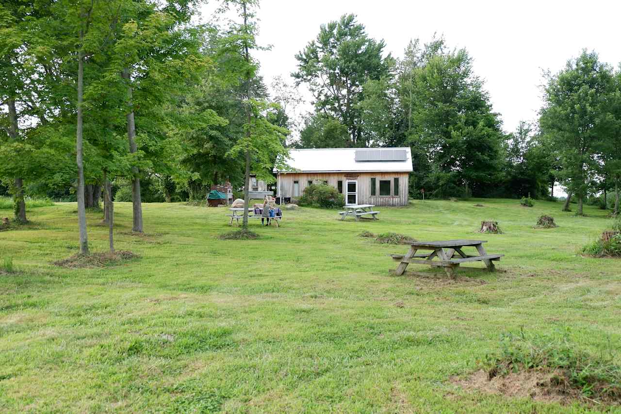 The cabin is close to the pond and has three picnic tables to eat at