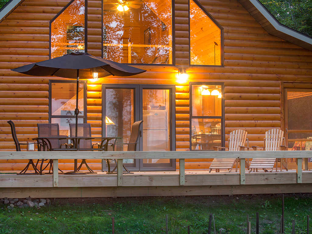 Twilight view of lighted cabin and front deck