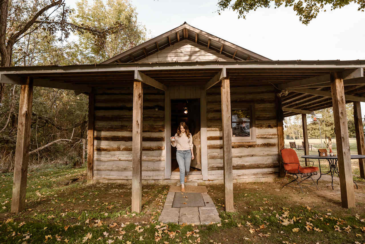 The cabin faces out onto the property and the old well house.