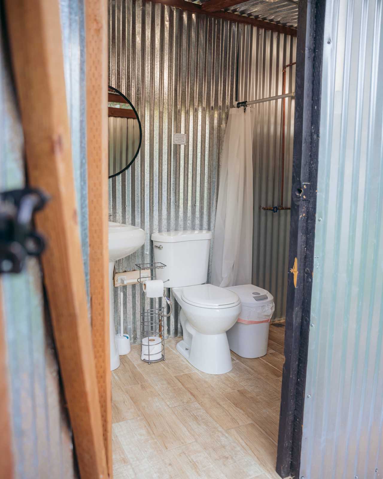 Restroom with full flush toilet, sink, shower with shampoo/conditioner/soap