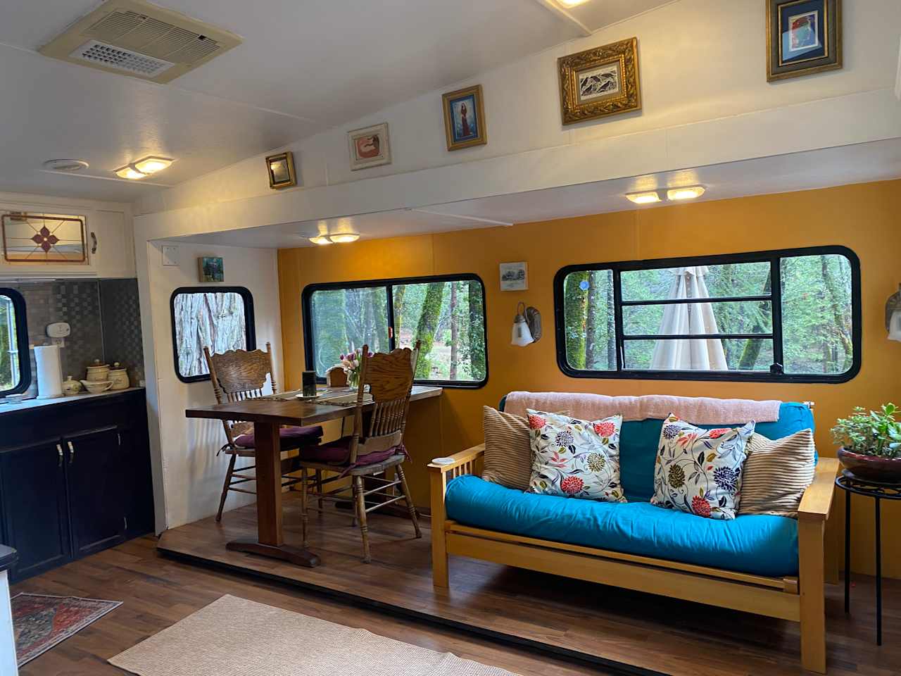 Colorful living area. The futon can provide extra sleeping area.  Dining area provides a beautiful views of the pond, stream and woods. 