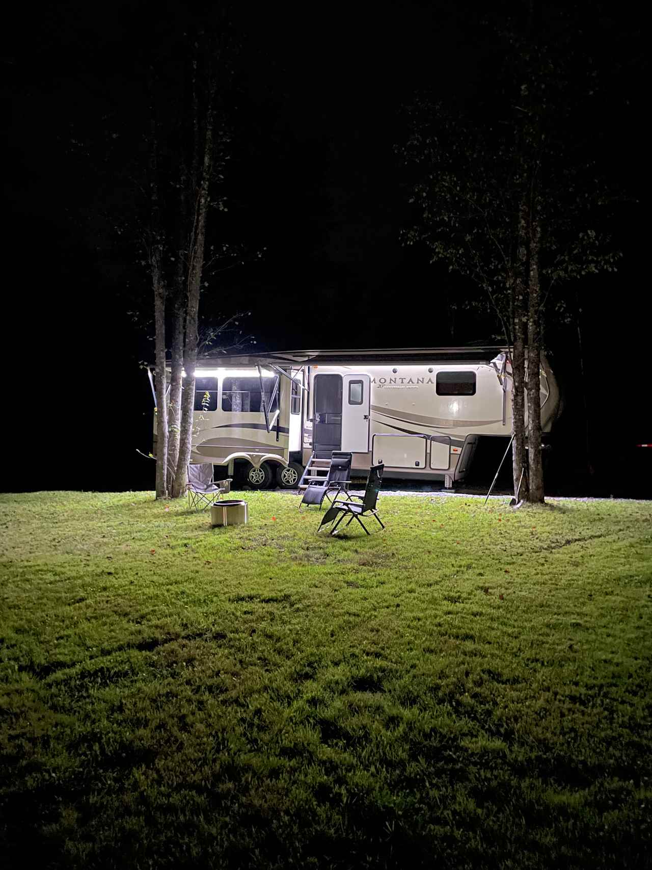 Gravel parking area with solo stove and lawn chairs
