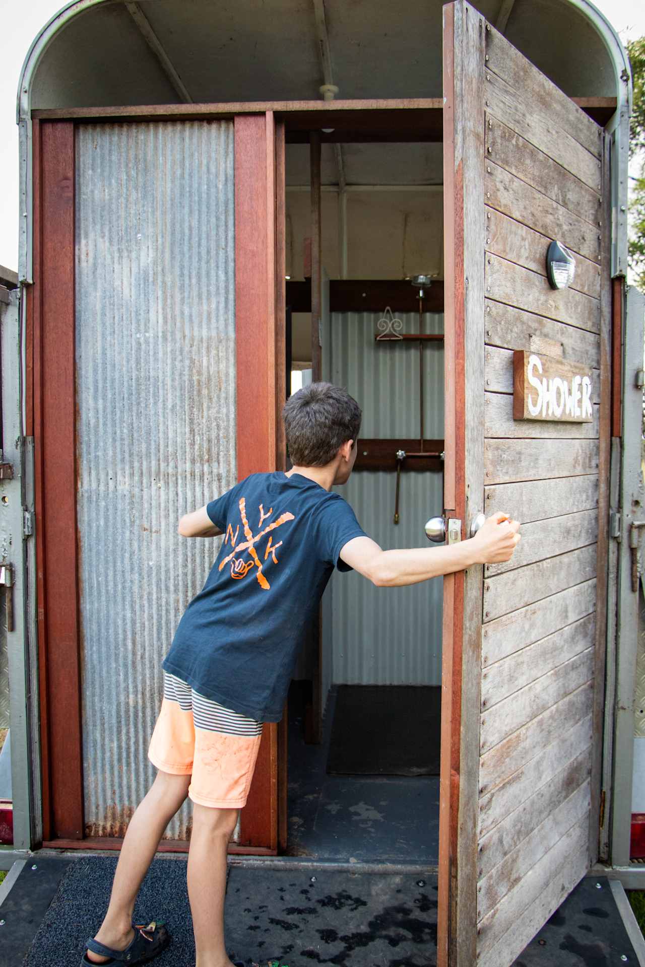 Quirky hot water shower in a converted horse float.