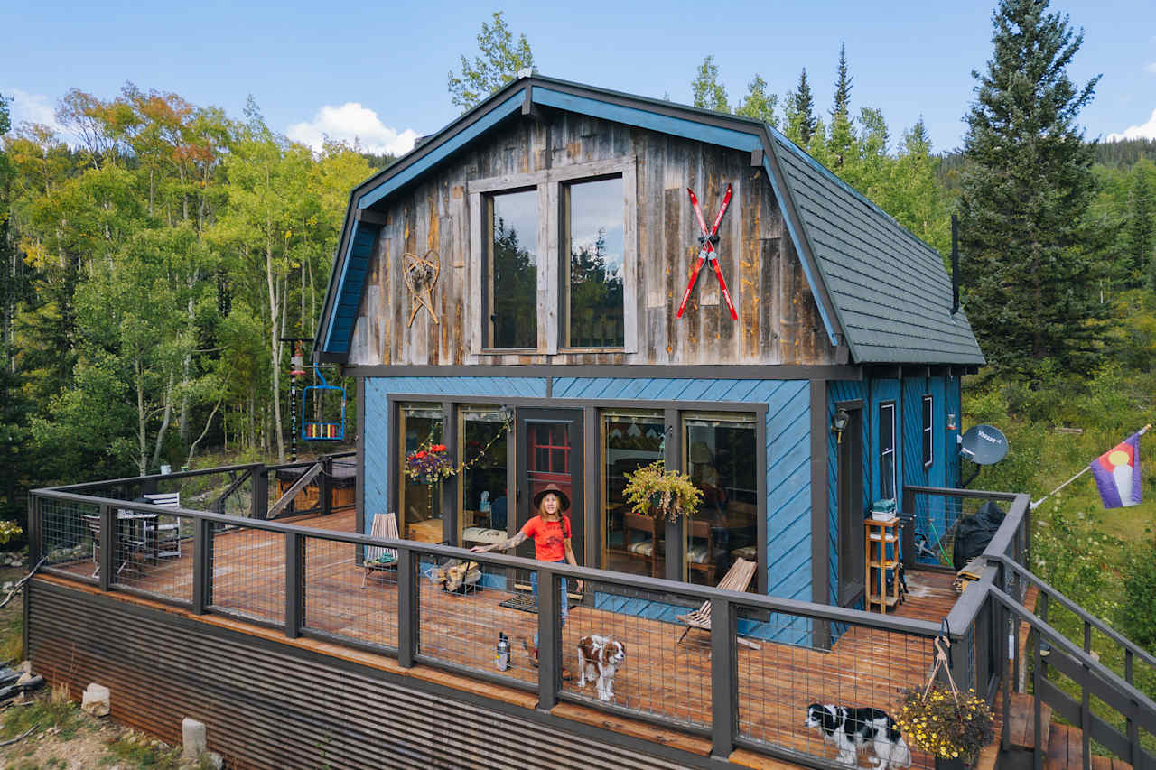 The cabin surrounded by aspens and pine trees