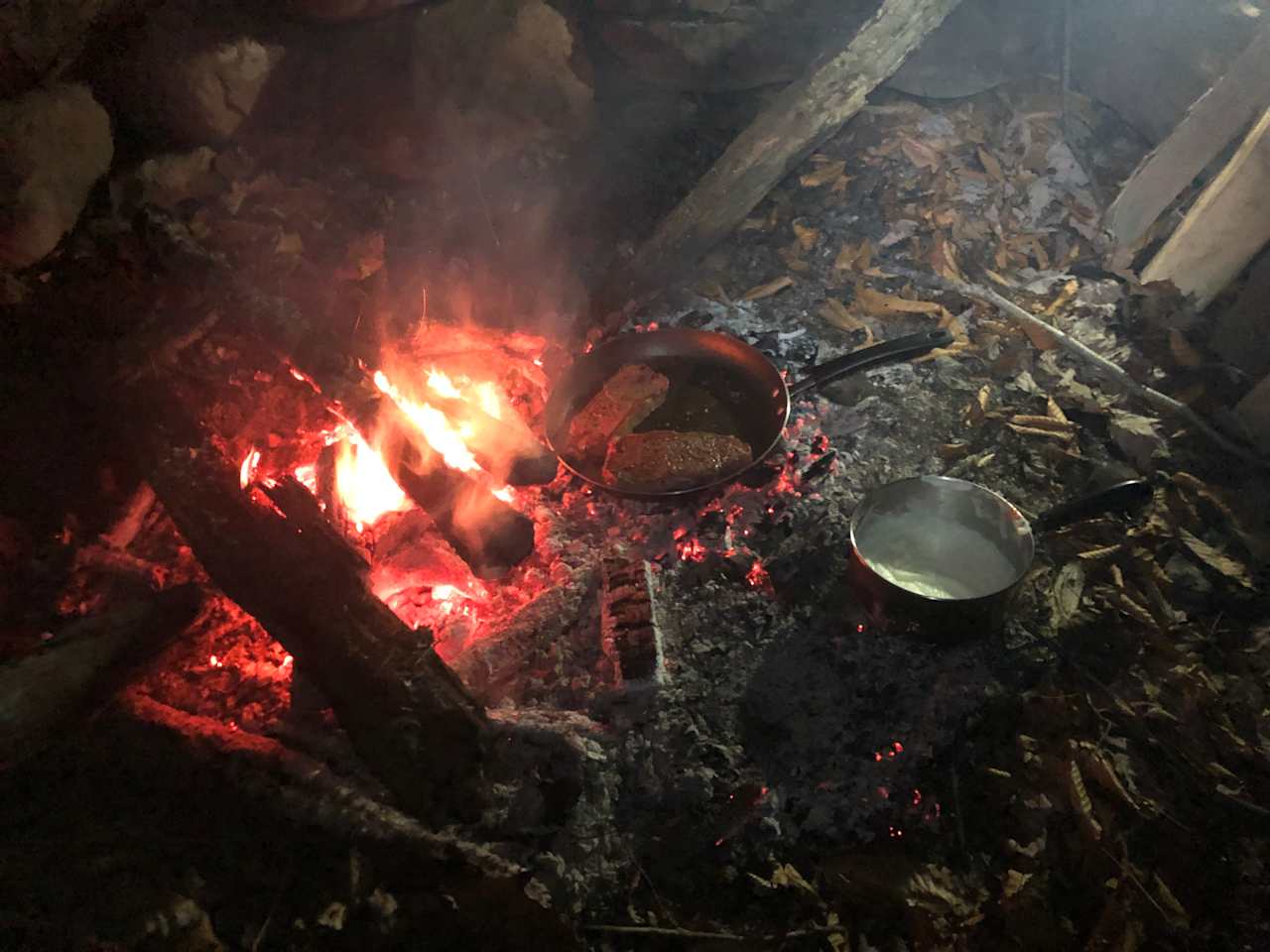 Frying up steak and potatoes in the fire pit
