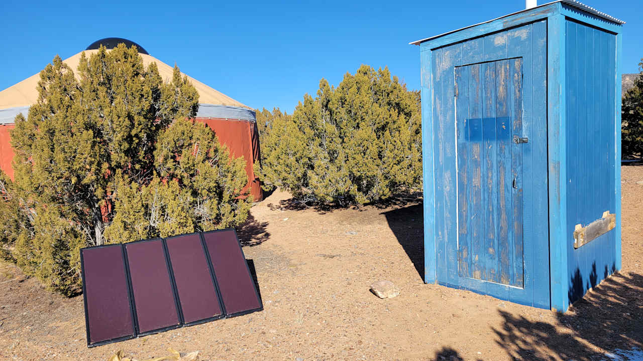 behind the yurt, solar panels and compost toilet outhouse