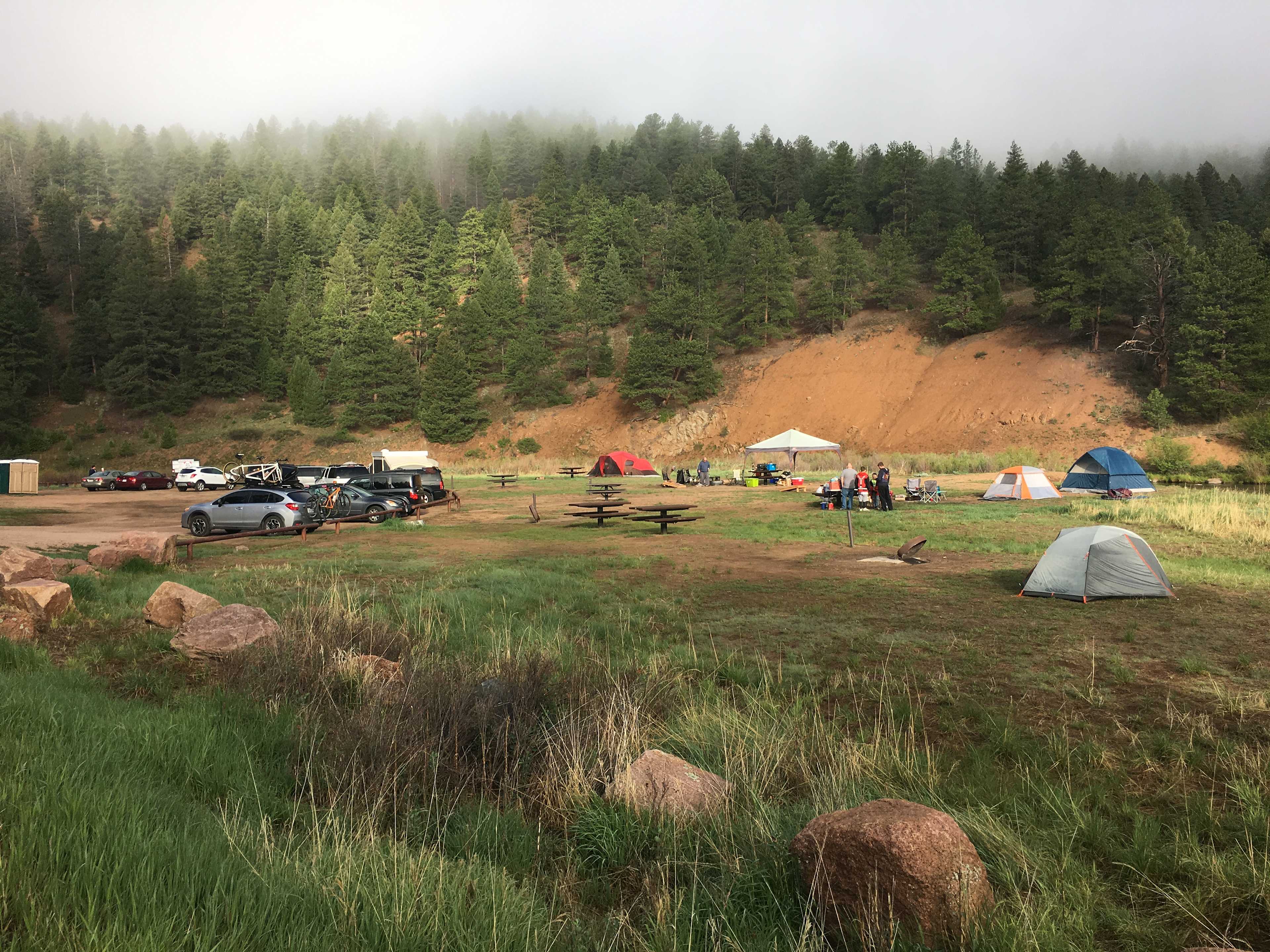 This is basically the whole campground. The river runs behind the sites to the right and the road is to the left .