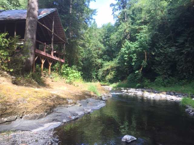 Cabin's covered porch overlooking the river. Please don't lean on the porch railing....it's tired.
