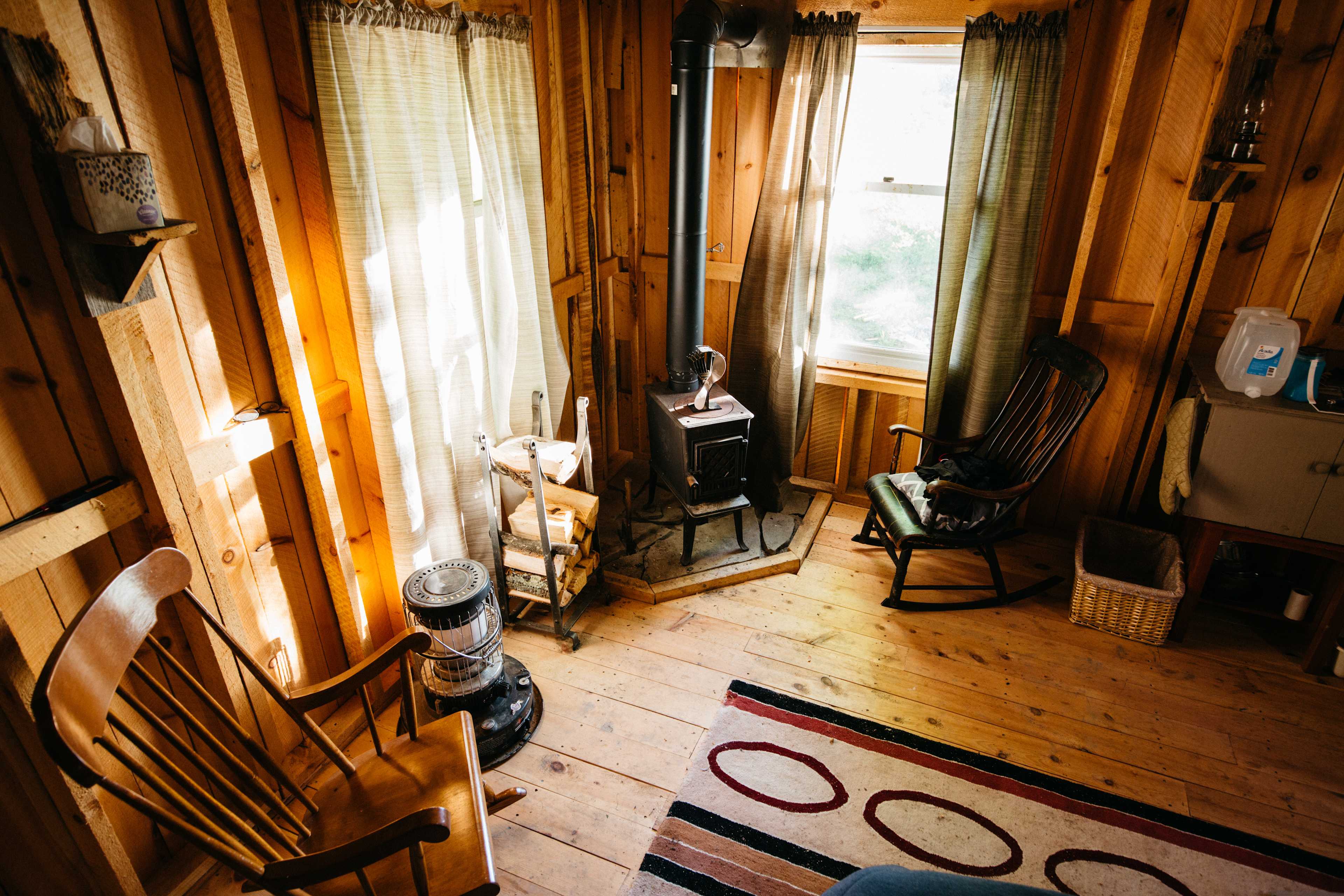 Interior of the cabin. Truly primitive, with a bed, rocking chairs, lanterns, wood burning stove, dishes and cutlery. Everything you need!