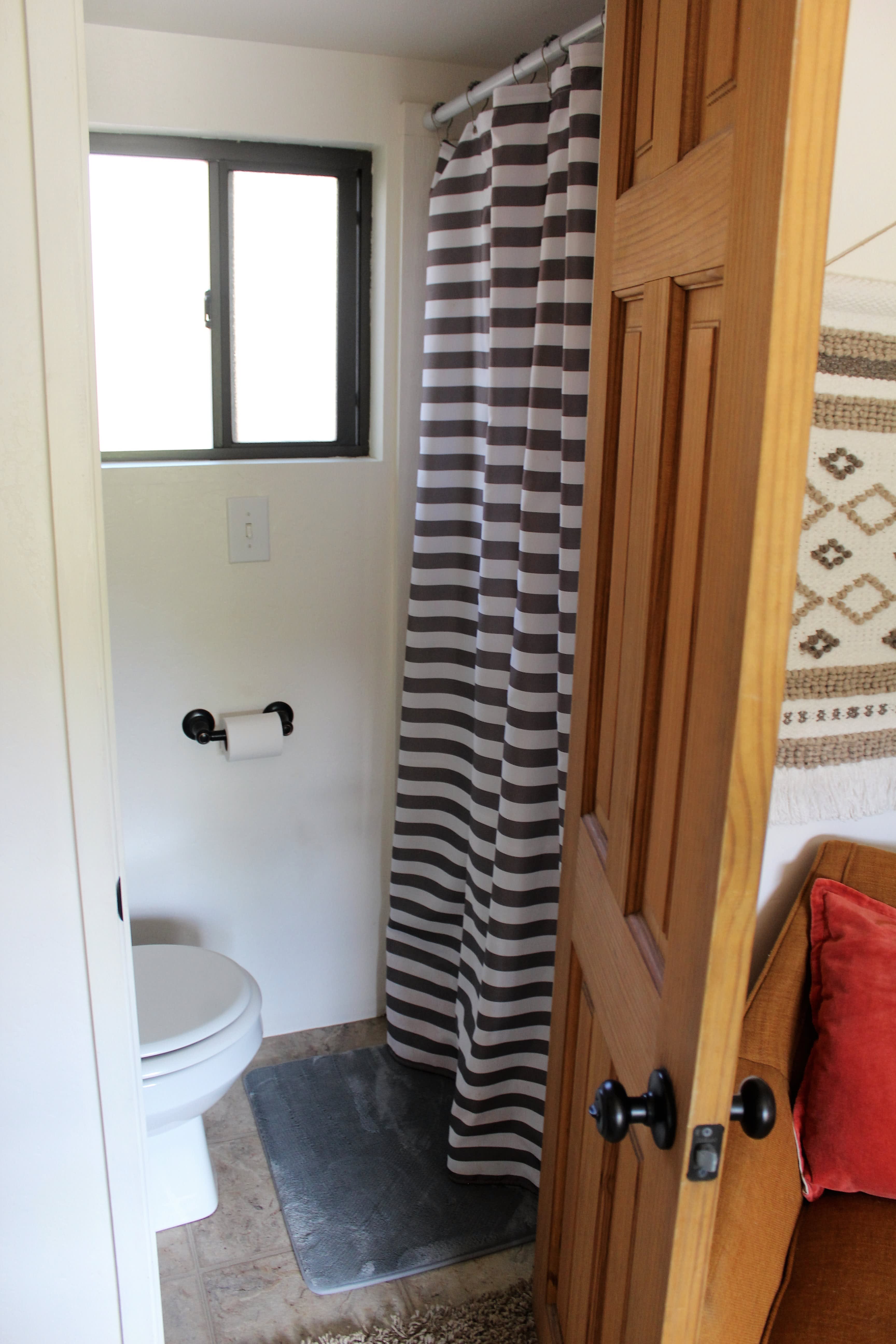 small bathroom with toilet and shower stall. Towels provided.