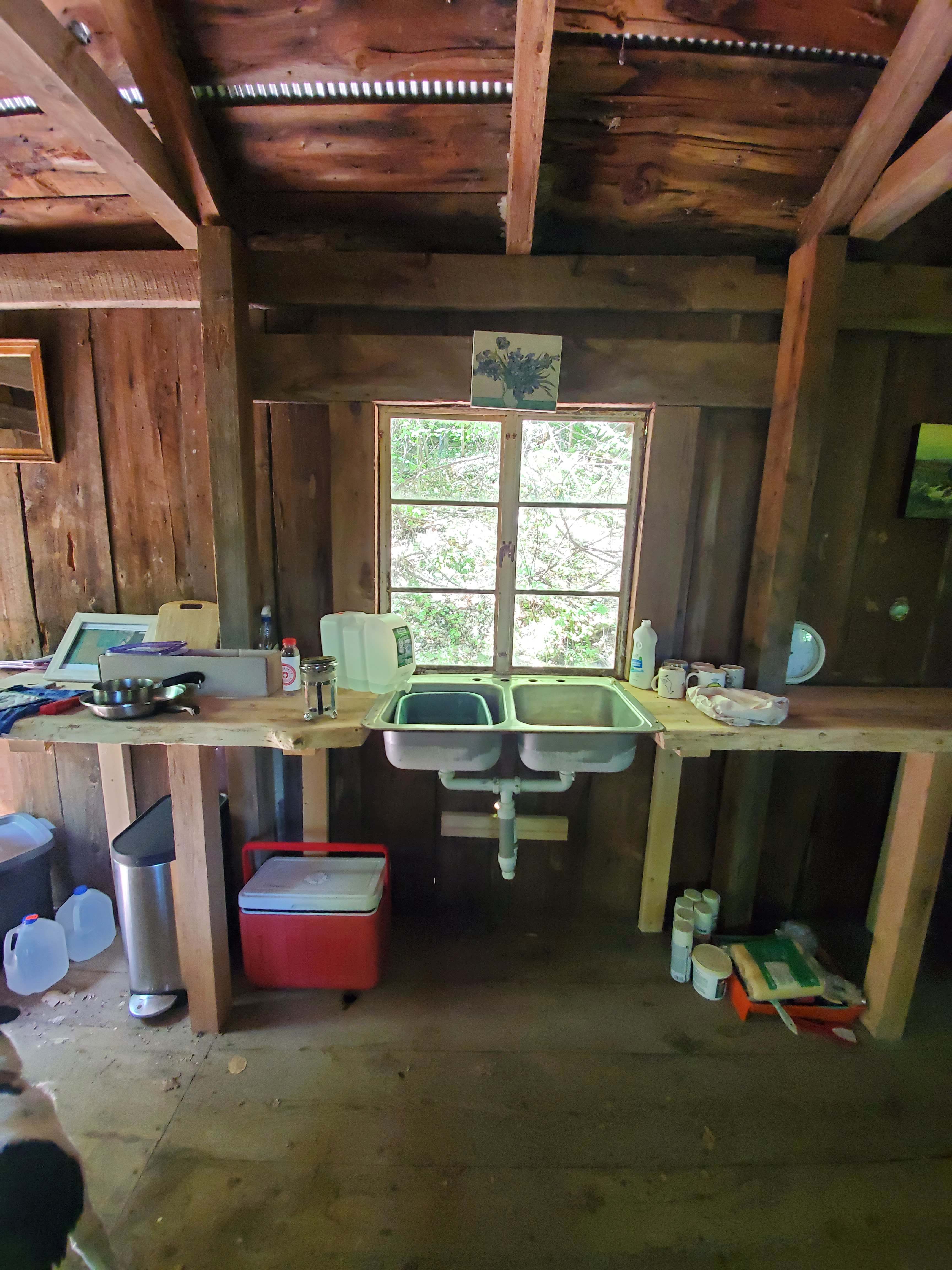 homemade wood counter/workspace and sink (no running water, just water containers)