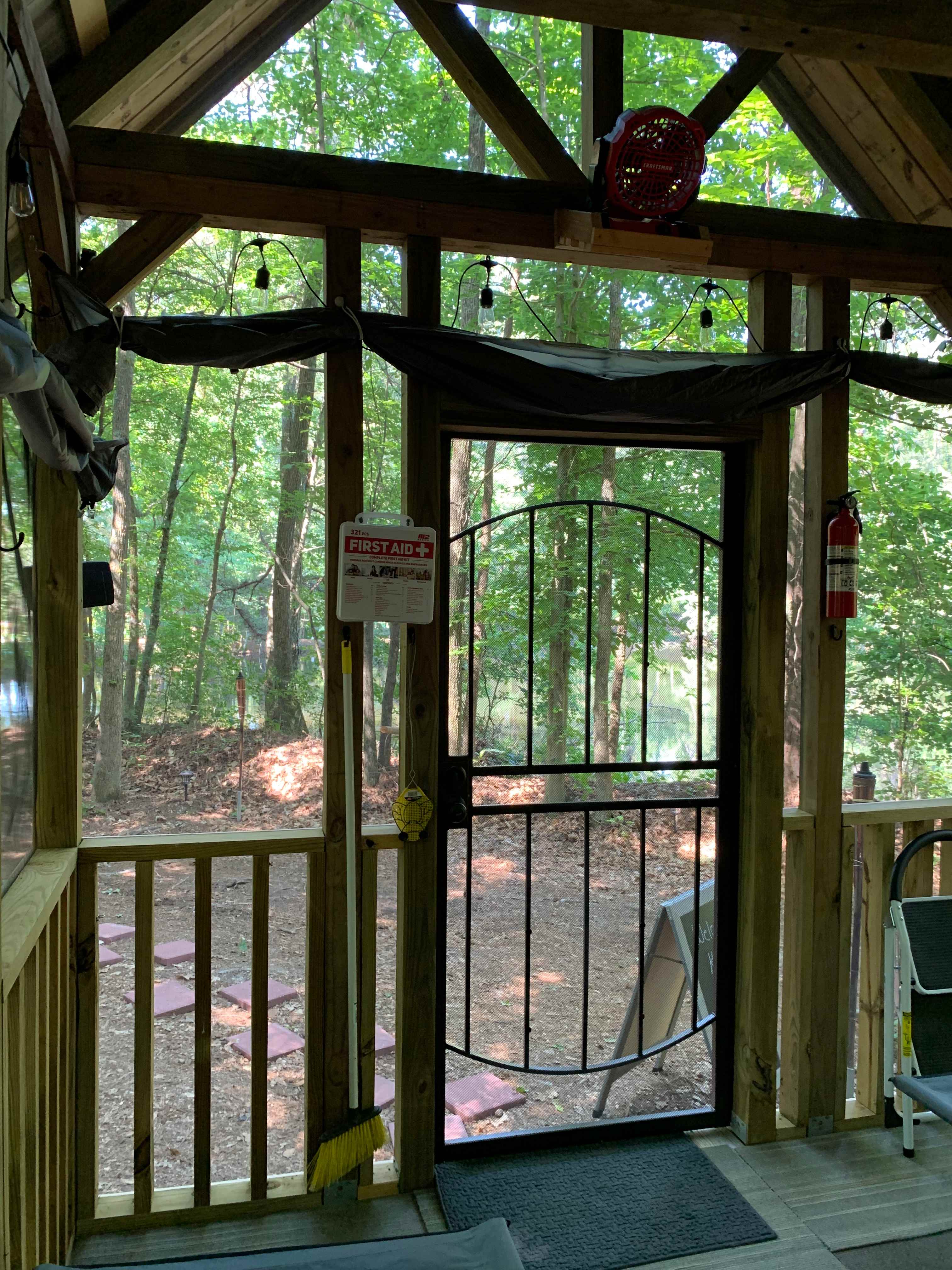 View from inside Tiny Cabin looking toward front of cabin. You can see the sun/shades that can be let down as well as the battery powered portable fan to help keep cool inside the cabin.