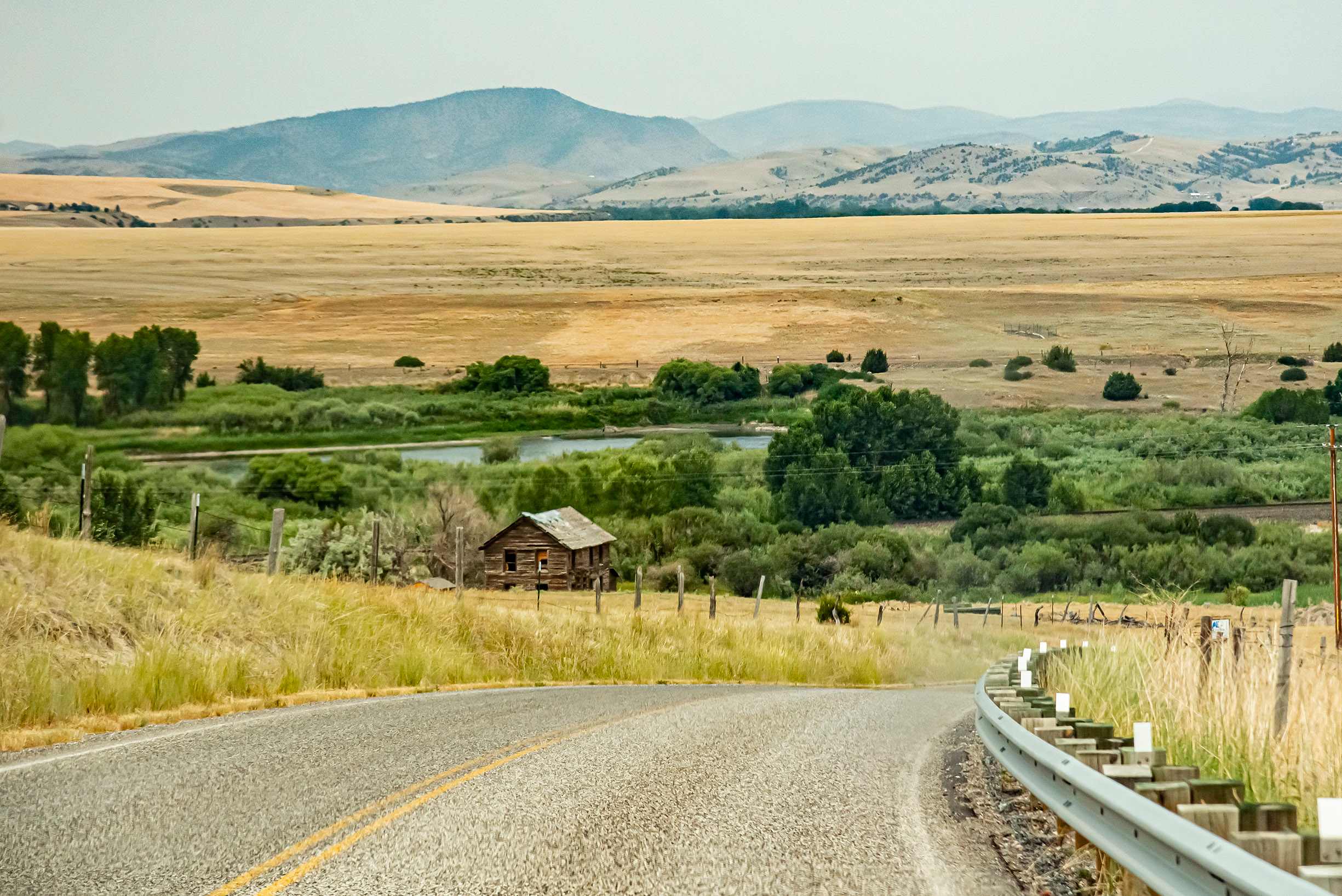 Log cabin overlooking the nearby Missouri River with mountains behind