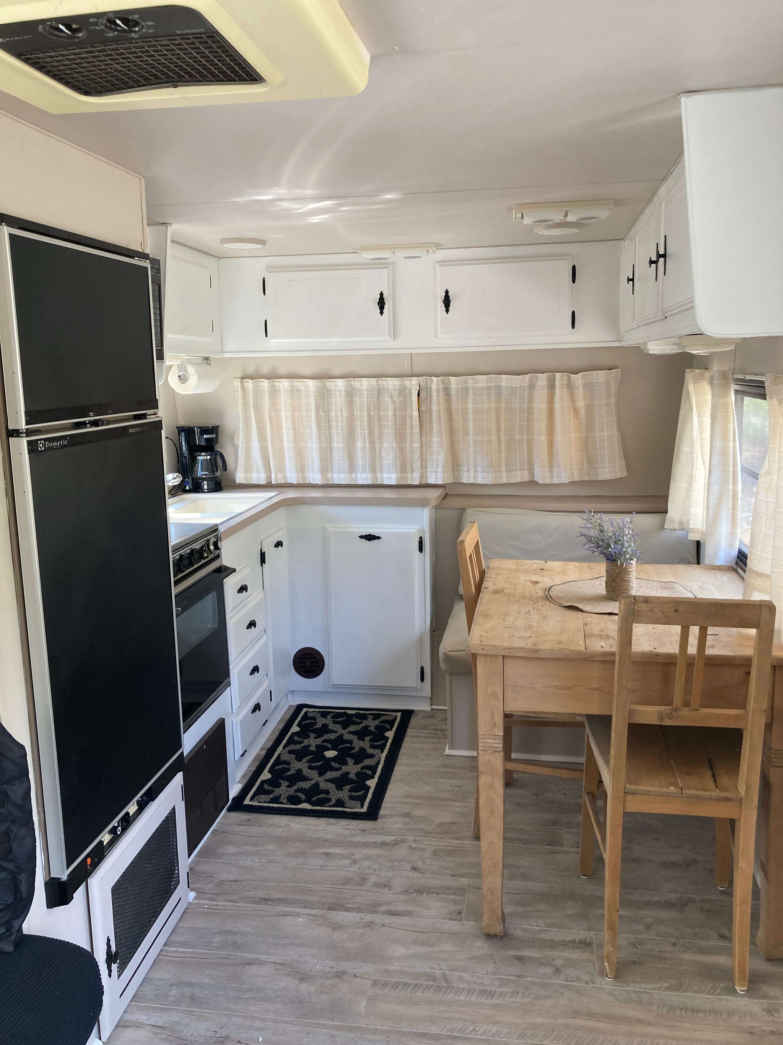 Fridge with  freezer , oven, stove,  microwave, cooking utensils and dishes.
